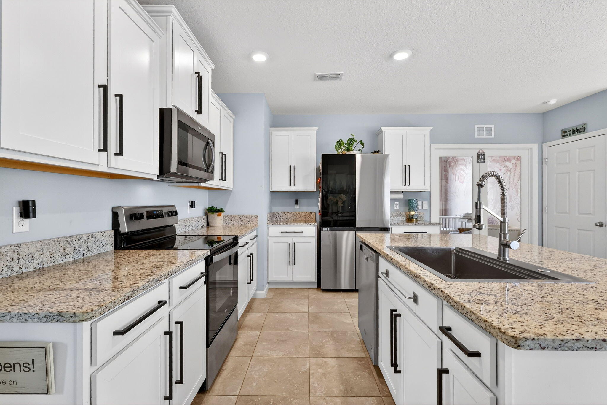 10897 Pacini Way Port St. Lucie, FL 34987 - Photo 3 of 35 a kitchen with granite countertop a sink stainless steel appliances and white cabinets