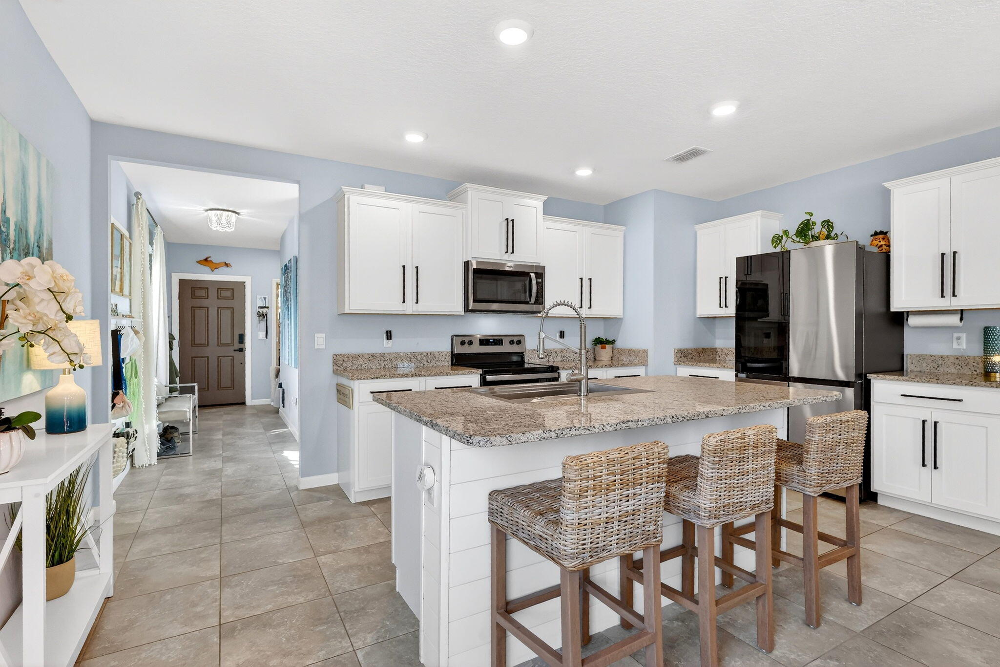 10897 Pacini Way Port St. Lucie, FL 34987 - Photo 4 of 35 a kitchen with stainless steel appliances granite countertop a stove top oven a sink a refrigerator a stove a dining table and chairs
