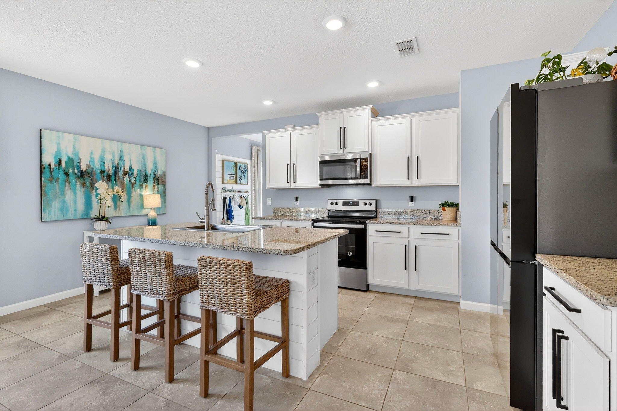 10897 Pacini Way Port St. Lucie, FL 34987 - Photo 5 of 35 a kitchen with white cabinets and stainless steel appliances