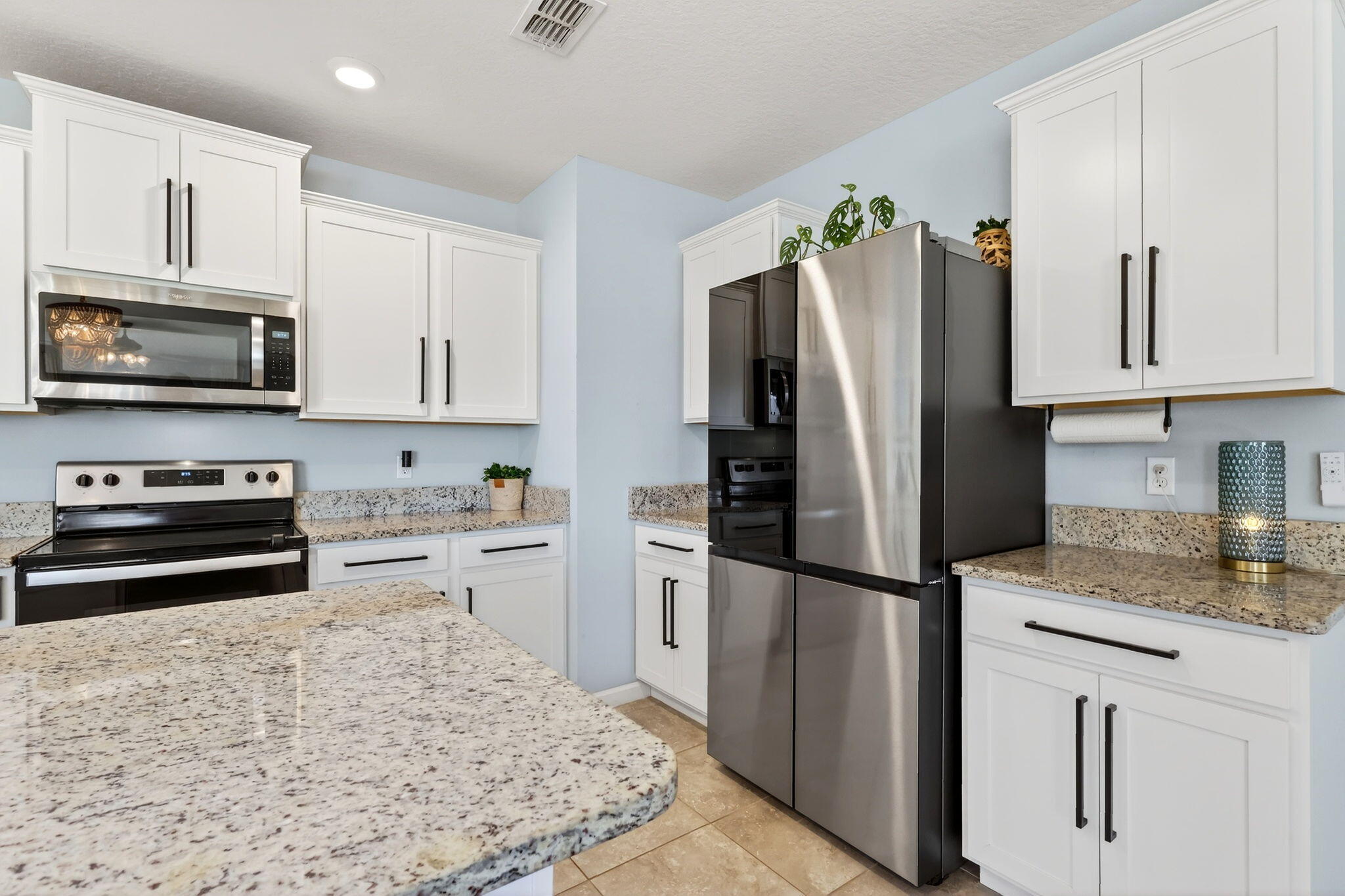 10897 Pacini Way Port St. Lucie, FL 34987 - Photo 6 of 35 a kitchen with a refrigerator stove and microwave