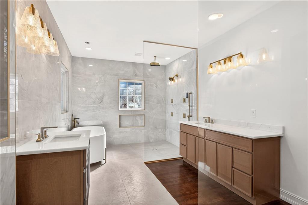 1330 West Wesley Road Northwest Atlanta, GA 30327 - Photo 19 of 46 a bathroom with a double vanity sink a mirror and a bathtub