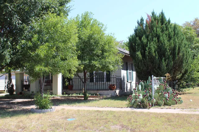 a view of a house with a yard and tree s