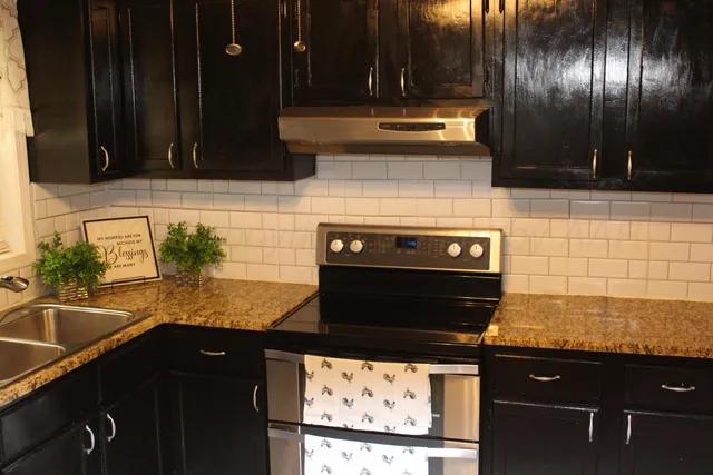 a kitchen with granite countertop a stove and cabinets