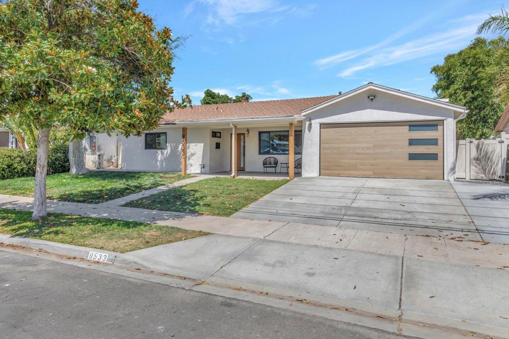 a front view of a house with yard and trees