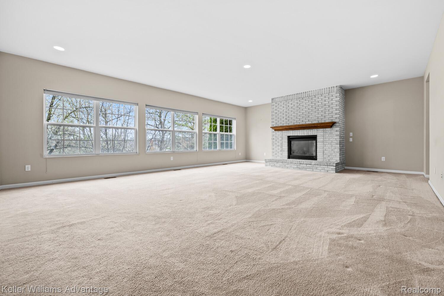 4100 Norwich Court Rochester, MI 48306 - Photo 11 of 72 Unfurnished living room featuring a fireplace, light colored carpet, and recessed lighting