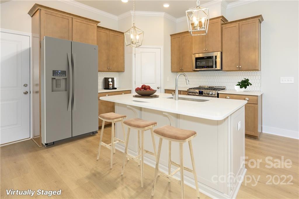 5915 Ardrey Kell Road Charlotte, NC 28105 - Photo 11 of 32 a kitchen with stainless steel appliances a sink a stove a refrigerator cabinets and chairs