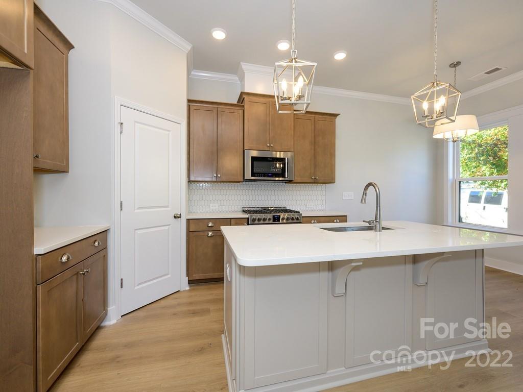5915 Ardrey Kell Road Charlotte, NC 28105 - Photo 13 of 32 a kitchen with kitchen island granite countertop a sink a center island and cabinets
