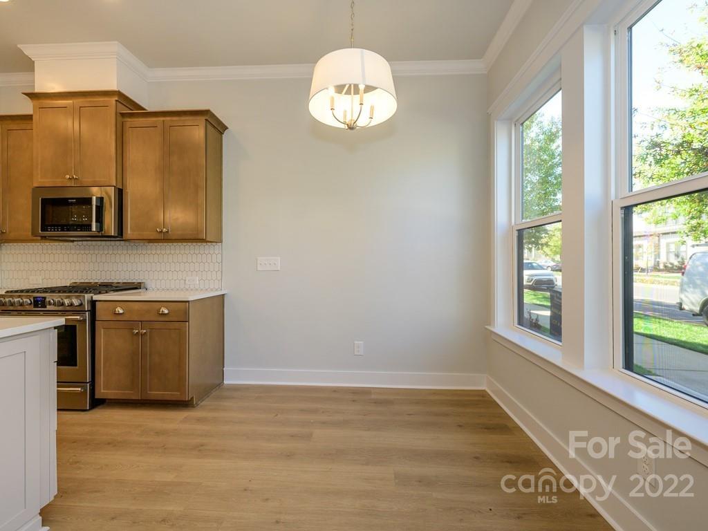 5915 Ardrey Kell Road Charlotte, NC 28105 - Photo 8 of 32 a view of a kitchen with granite countertop cabinets and a wooden floor