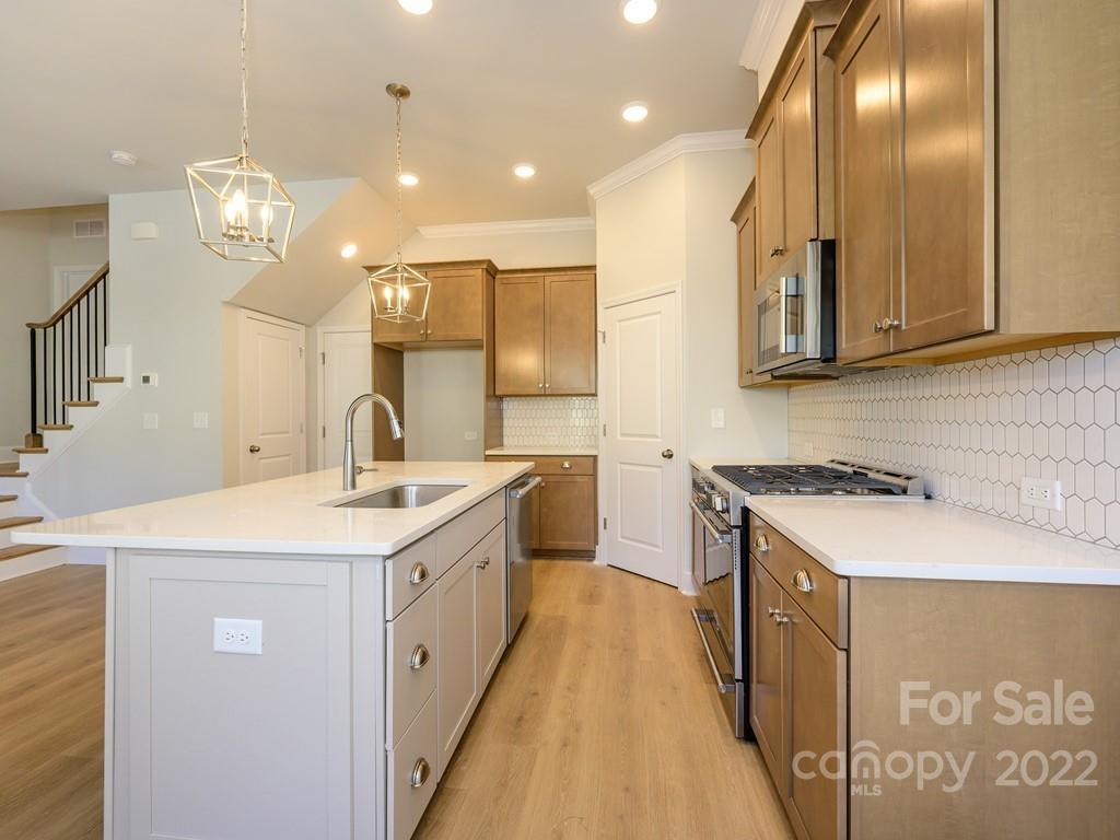5915 Ardrey Kell Road Charlotte, NC 28105 - Photo 10 of 32 a kitchen with stainless steel appliances granite countertop a sink a stove and a refrigerator