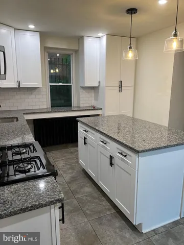 a kitchen with granite countertop stainless steel appliances a sink stove and refrigerator