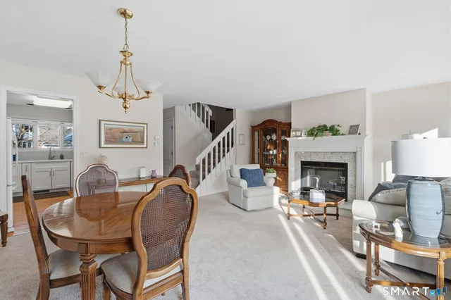 a dining room with furniture a fireplace and wooden floor