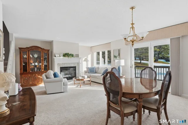 a living room with furniture a chandelier and a fireplace