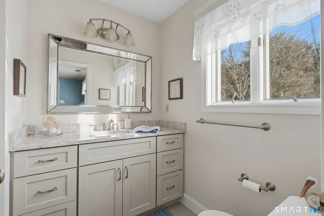 a bathroom with a double vanity sink and mirror with window