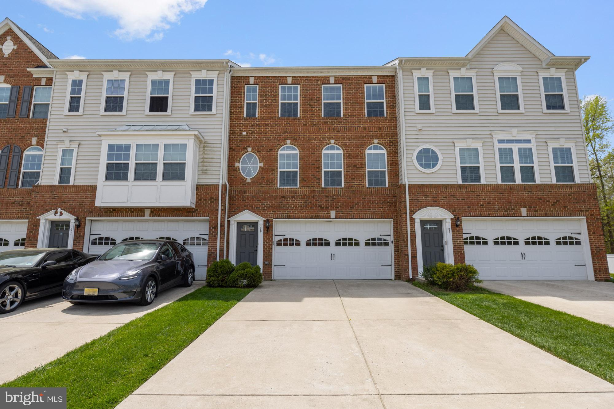 a front view of a building with cars parked