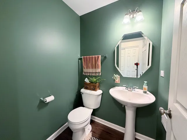 a bathroom with a toilet sink and mirror