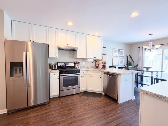a kitchen with a refrigerator stove and wooden cabinets