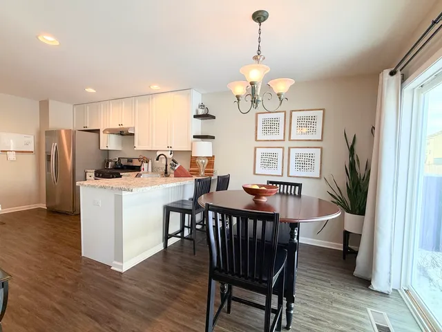 a view of a dining room with furniture a chandelier and wooden floor