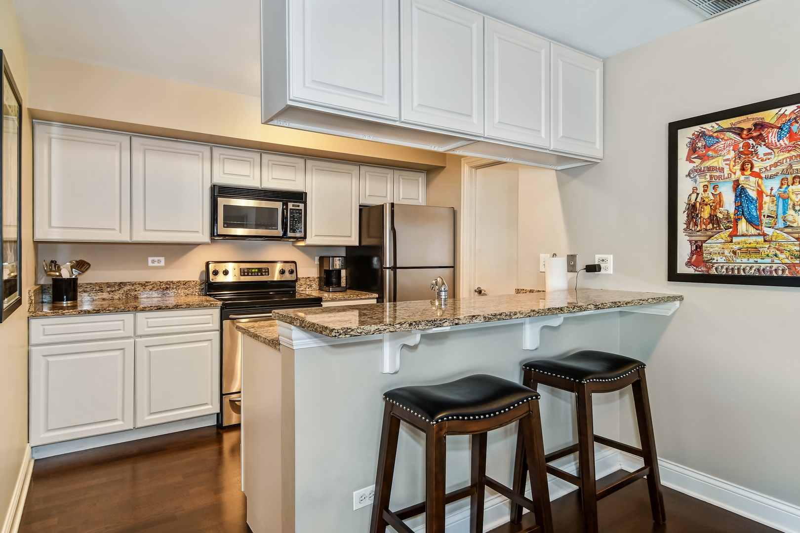 11 Foxcroft Road, Unit 219 Naperville, IL 60565 - Photo 6 of 16 a kitchen with stainless steel appliances kitchen island granite countertop a table chairs microwave and sink