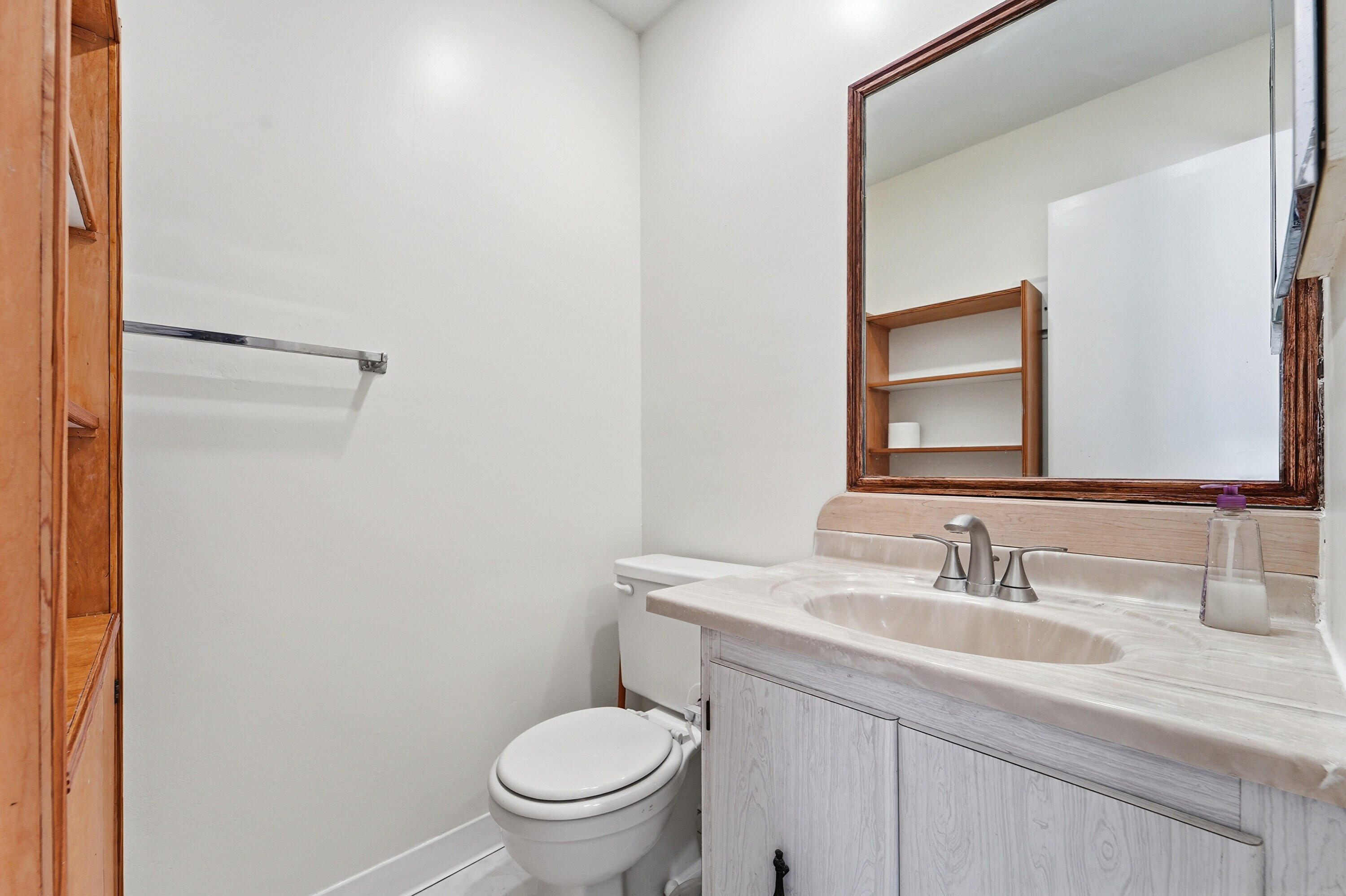 226 Normandy Lane, Unit E Delray Beach, FL 33484 - Photo 13 of 35 a bathroom with a granite countertop sink toilet and a mirror