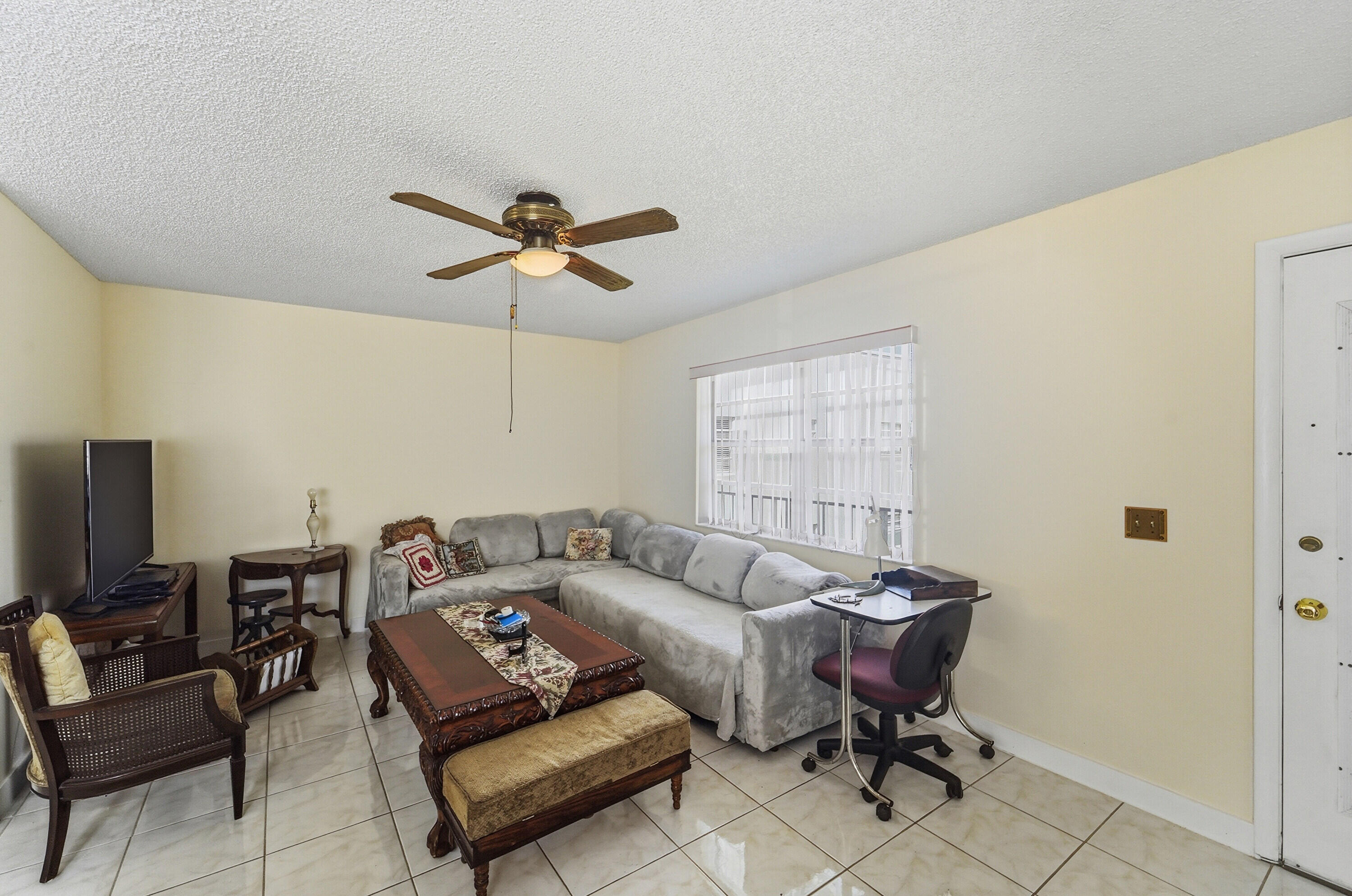 226 Normandy Lane, Unit E Delray Beach, FL 33484 - Photo 4 of 35 a living room with furniture and a ceiling fan