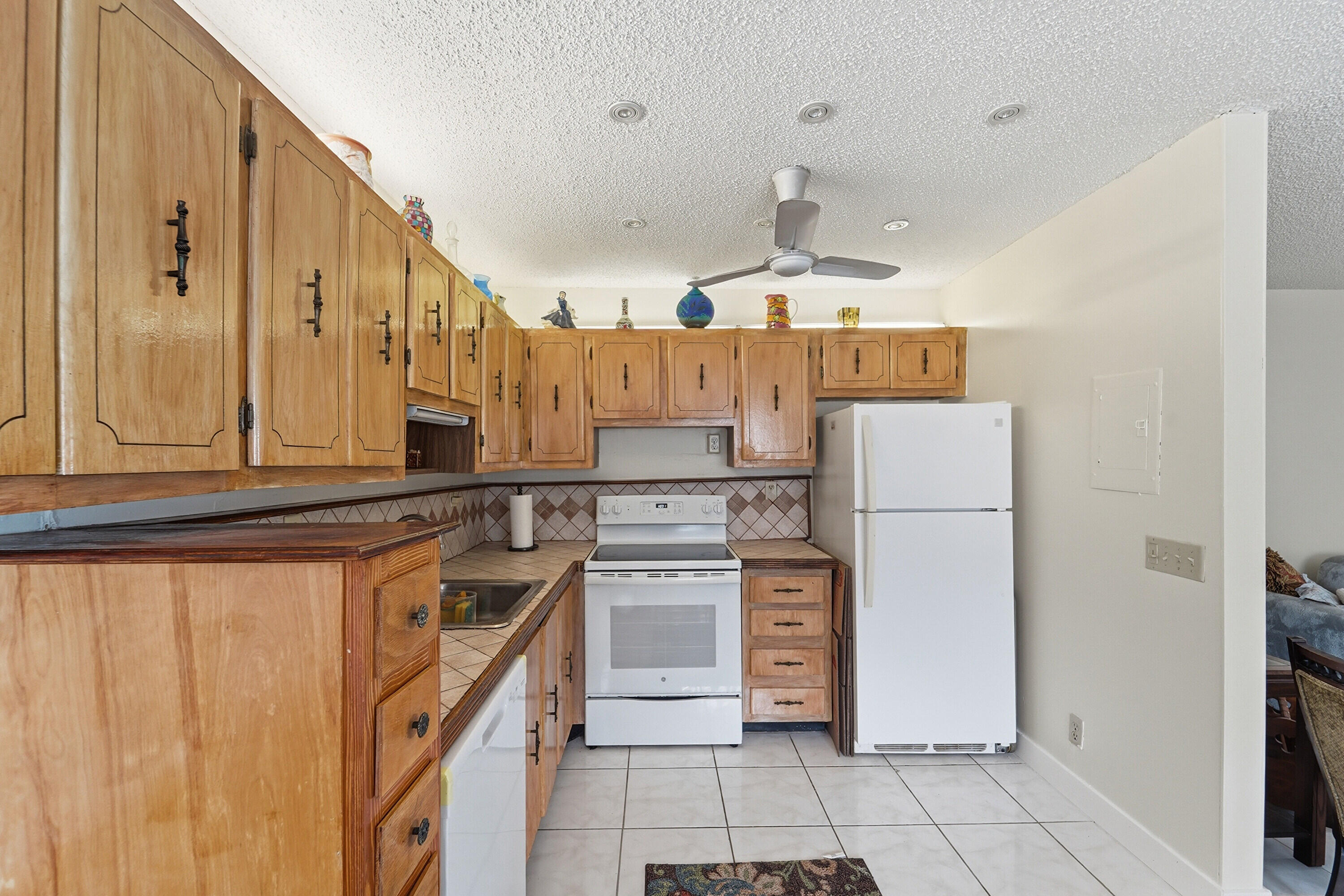 226 Normandy Lane, Unit E Delray Beach, FL 33484 - Photo 8 of 35 a kitchen with a refrigerator a stove top oven and cabinets