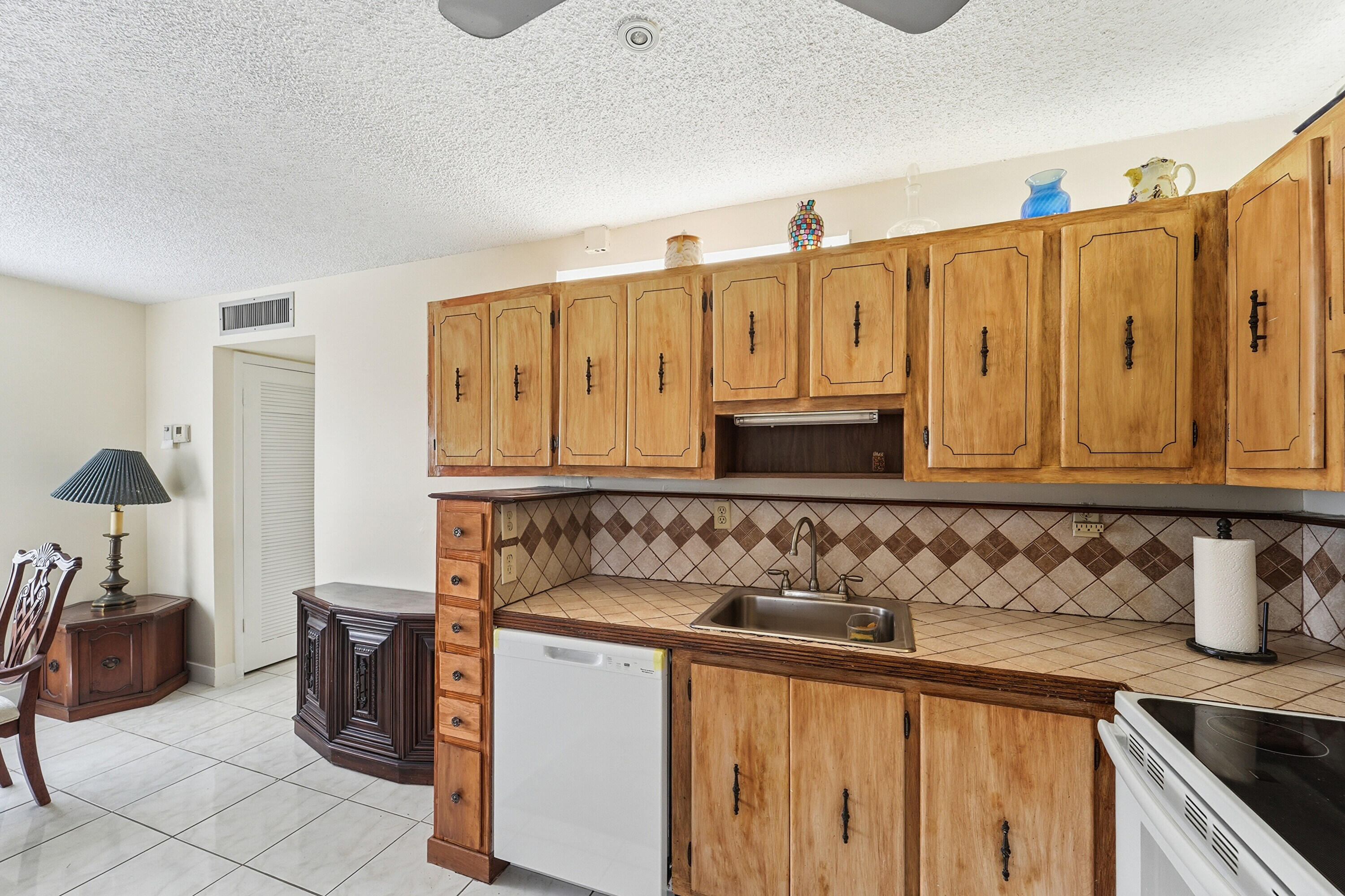 226 Normandy Lane, Unit E Delray Beach, FL 33484 - Photo 9 of 35 a kitchen with stainless steel appliances granite countertop a sink and cabinets