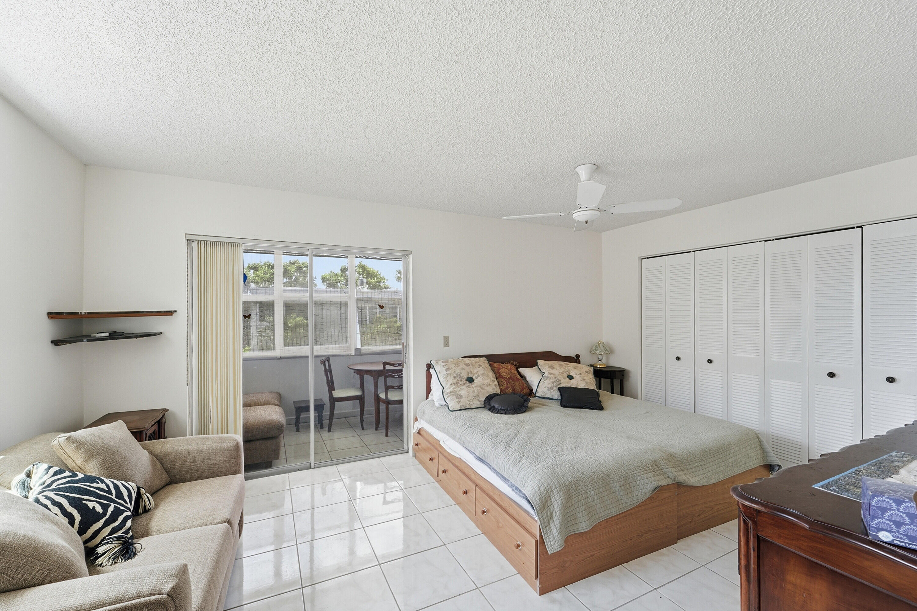 226 Normandy Lane, Unit E Delray Beach, FL 33484 - Photo 10 of 35 a bedroom with a bed and a couch