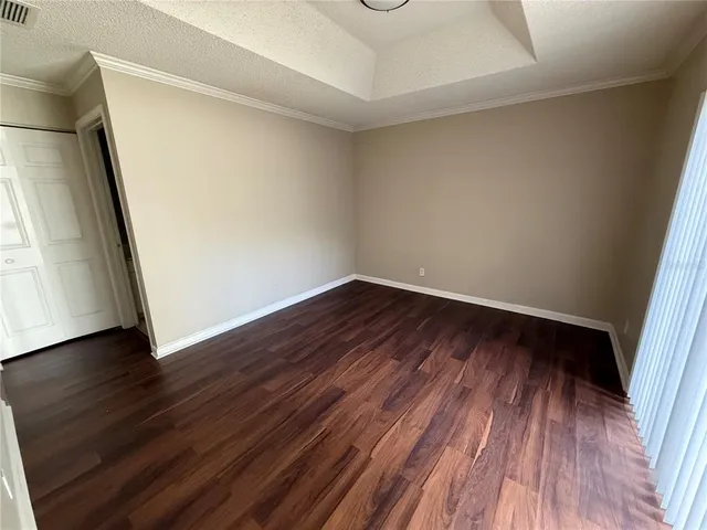 an empty room with wooden floor and entrance