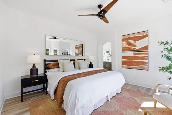a bedroom with a bed wooden floor and window