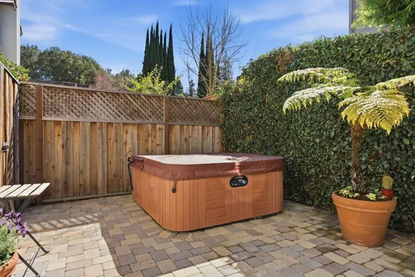a view of a backyard with plants and wooden fence