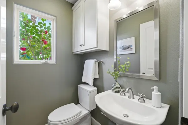 a bathroom with a toilet a sink and a mirror