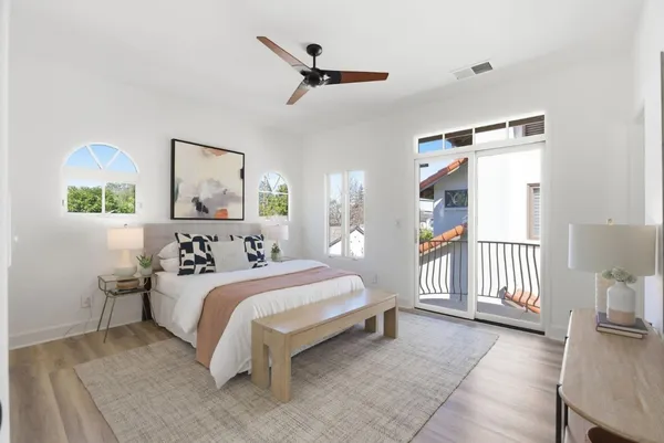 a bedroom with a bed a couch and a painting on the wall