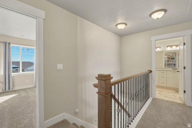 836 South 250 West Vernal, UT 84078 - Photo 33 of 56 Hallway with light colored carpet and an upstairs landing
