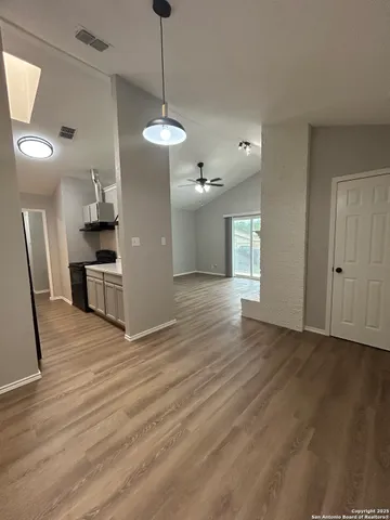 a view of a kitchen with wooden floor and a ceiling fan