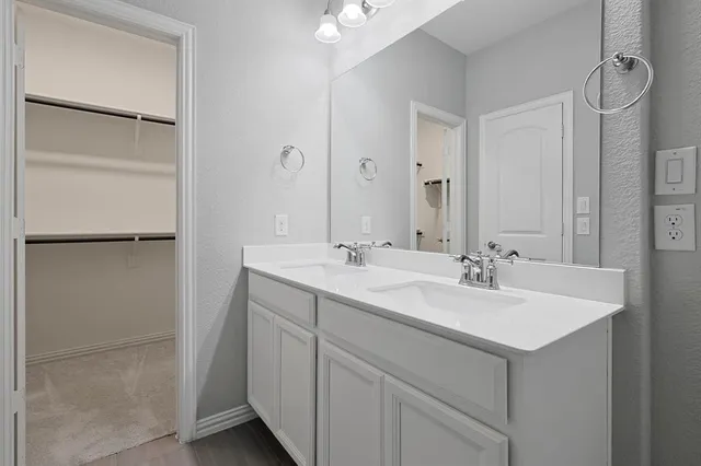 a bathroom with a granite countertop bathtub shower sink vanity mirror and toilet