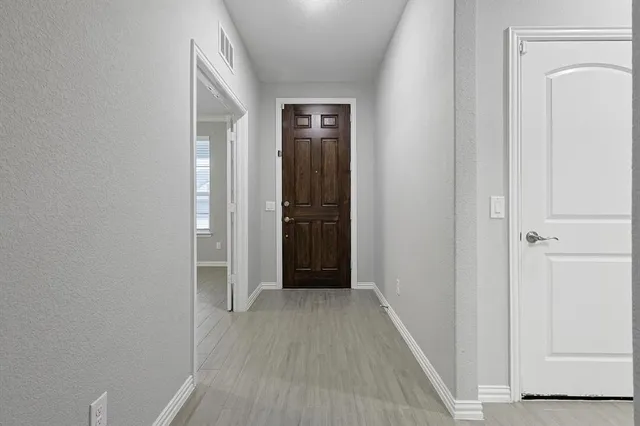 a kitchen with stainless steel appliances white cabinets and wooden floor