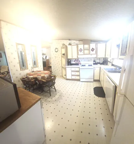 a kitchen with a sink a stove a refrigerator and a dining table