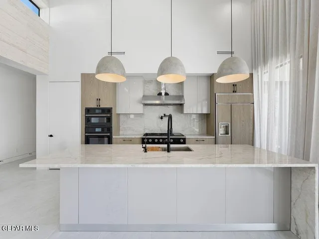 a kitchen with stainless steel appliances granite countertop a sink a stove and a wooden floors