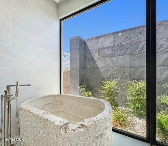 an empty room with windows and ceiling fan