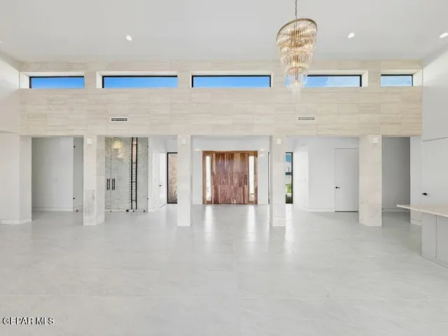 a kitchen with stainless steel appliances granite countertop a sink a stove a refrigerator and white cabinets