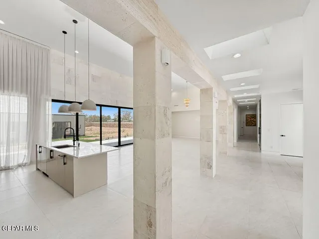 a large white kitchen with kitchen island a sink a stove and a refrigerator