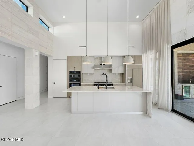 a kitchen with stainless steel appliances granite countertop a sink a stove and a refrigerator