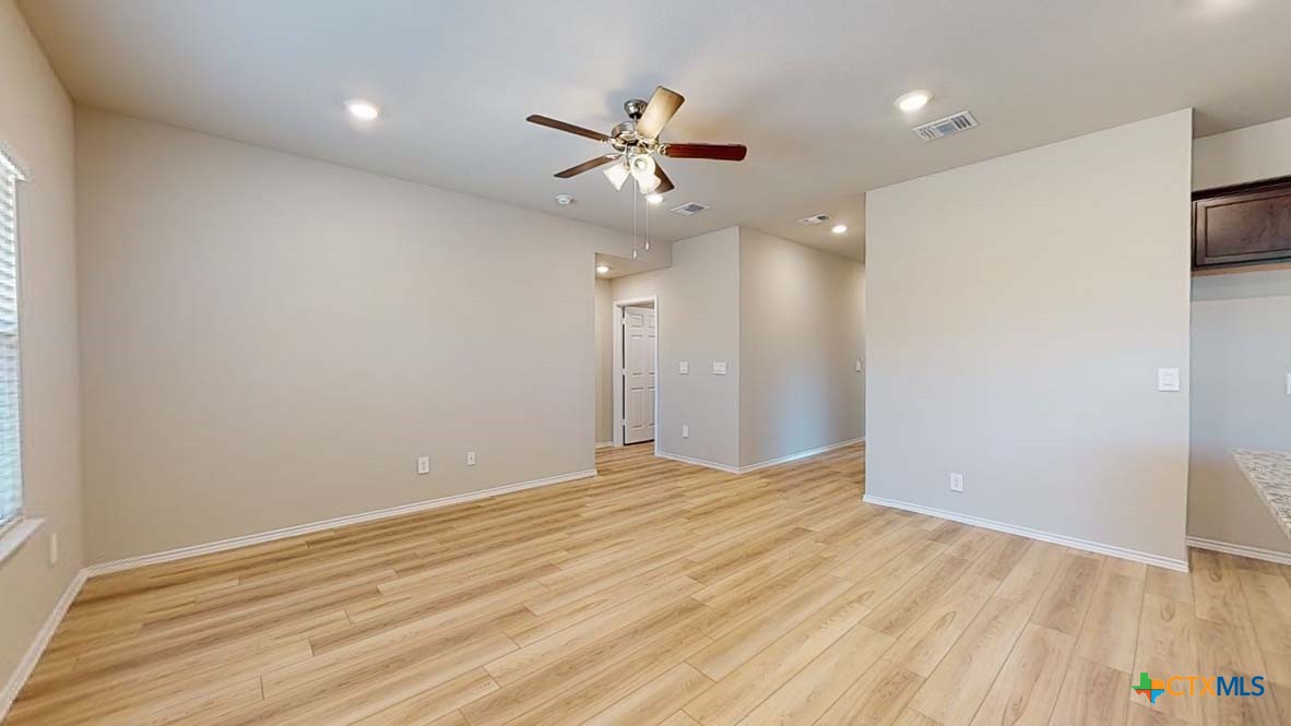 549 Hector Loop Georgetown, TX 78626 - Photo 5 of 22 an empty room with wooden floor and a ceiling fan