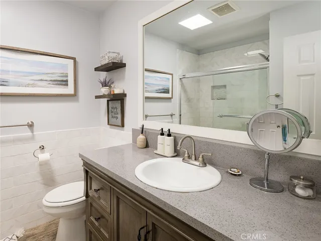 a bathroom with a granite countertop double vanity and a mirror