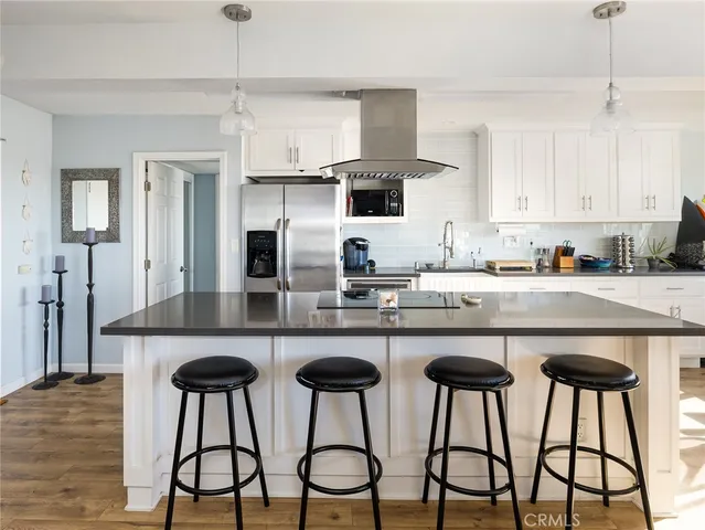 a kitchen with stainless steel appliances a table chairs refrigerator and microwave