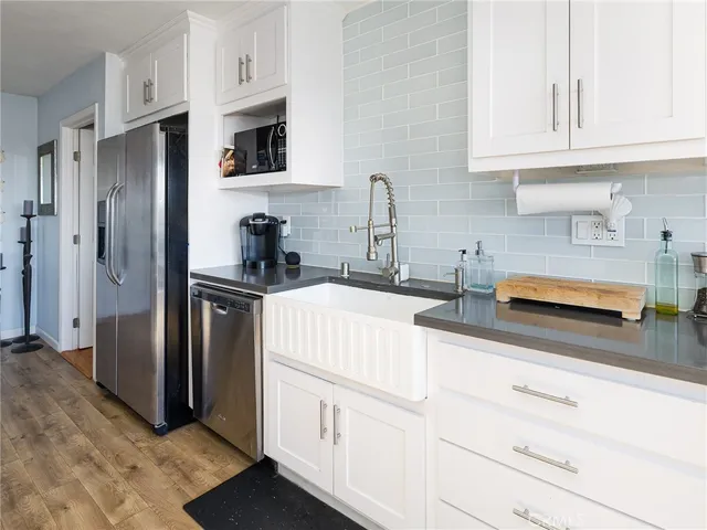 a kitchen with stainless steel appliances granite countertop a refrigerator sink and white cabinets