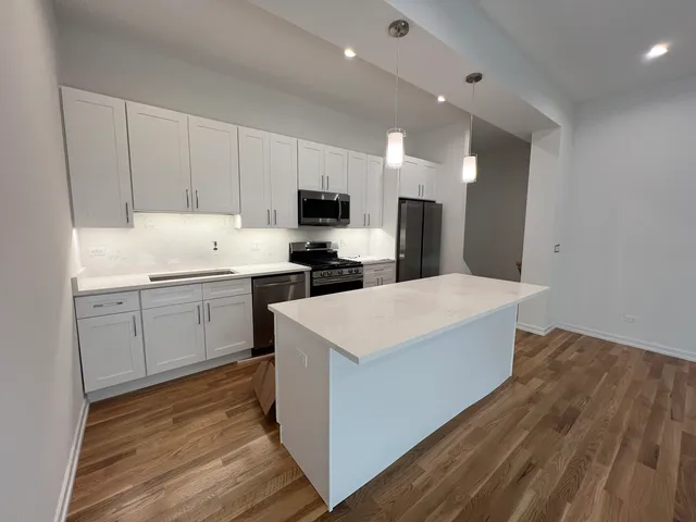 a view of kitchen with wooden floor electronic appliances and window