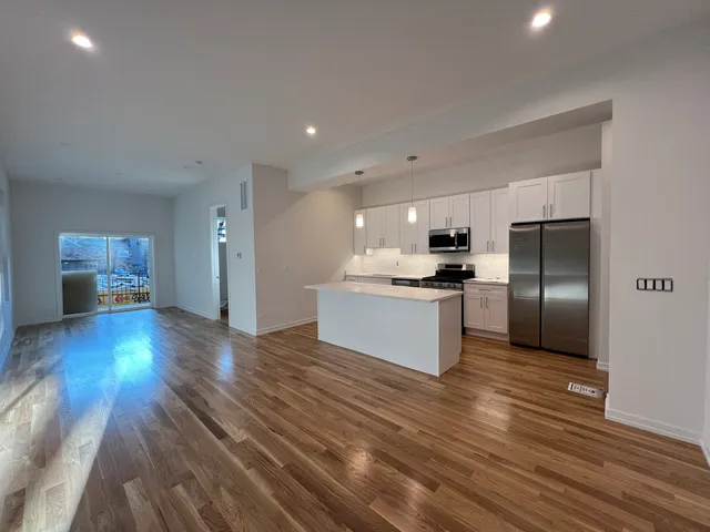 a kitchen with a sink a stove a refrigerator and white cabinets