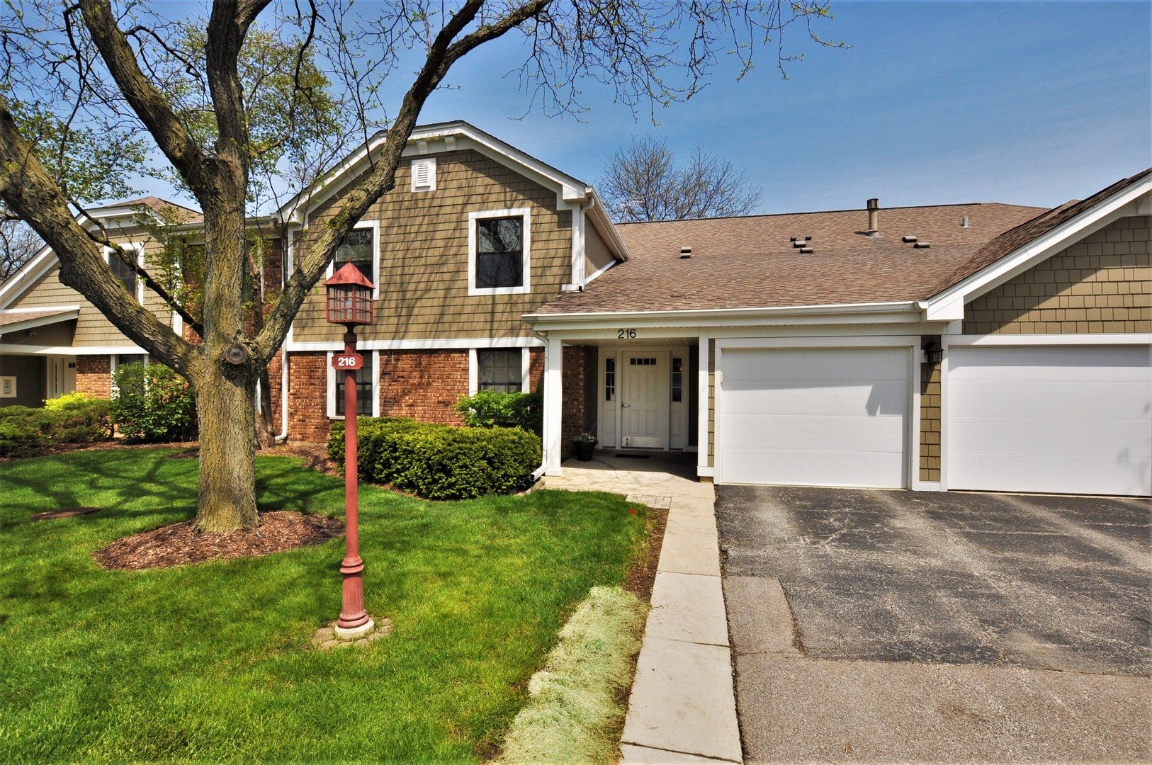216 Deerpath Court, Unit D1 Schaumburg, IL 60193 - Photo 1 of 16 a front view of a house with a yard and garage