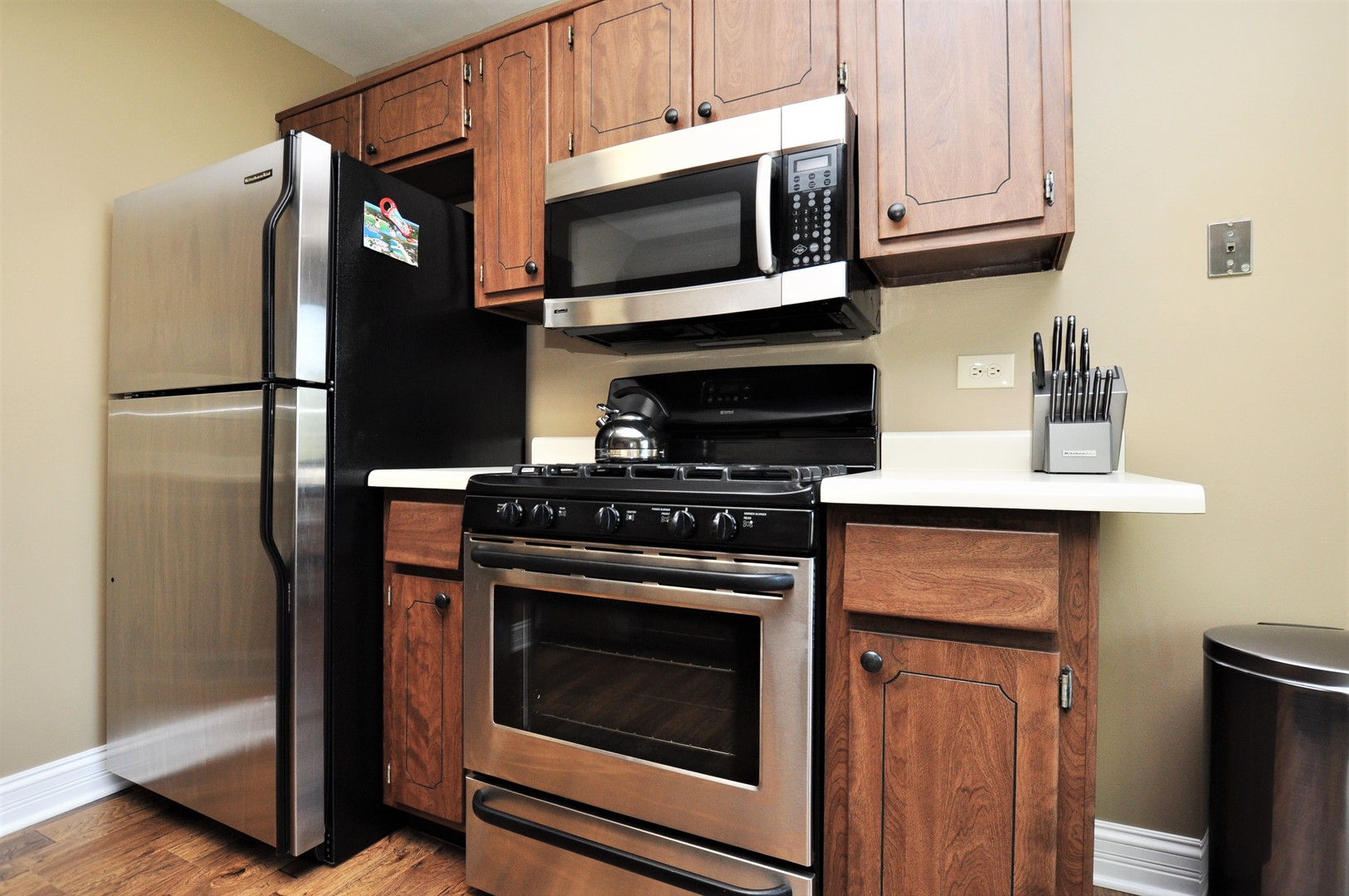 216 Deerpath Court, Unit D1 Schaumburg, IL 60193 - Photo 7 of 16 a kitchen with granite countertop wooden cabinets and stainless steel appliances